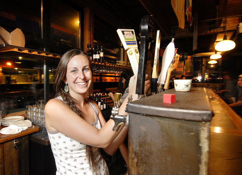 Bartender Katie Margo draws a beer at Flatbread Co. on Portland’s waterfront. Most brews are about $4 and wine is served by the glass.