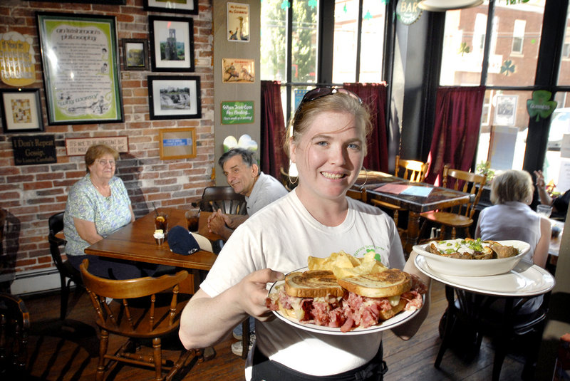 Risa Callan serves a Reuben sandwich and potato skins at Byrnes’ Irish Pub in Bath. The pub hosts an Irish-American sing-along on Sunday evenings and other music events.