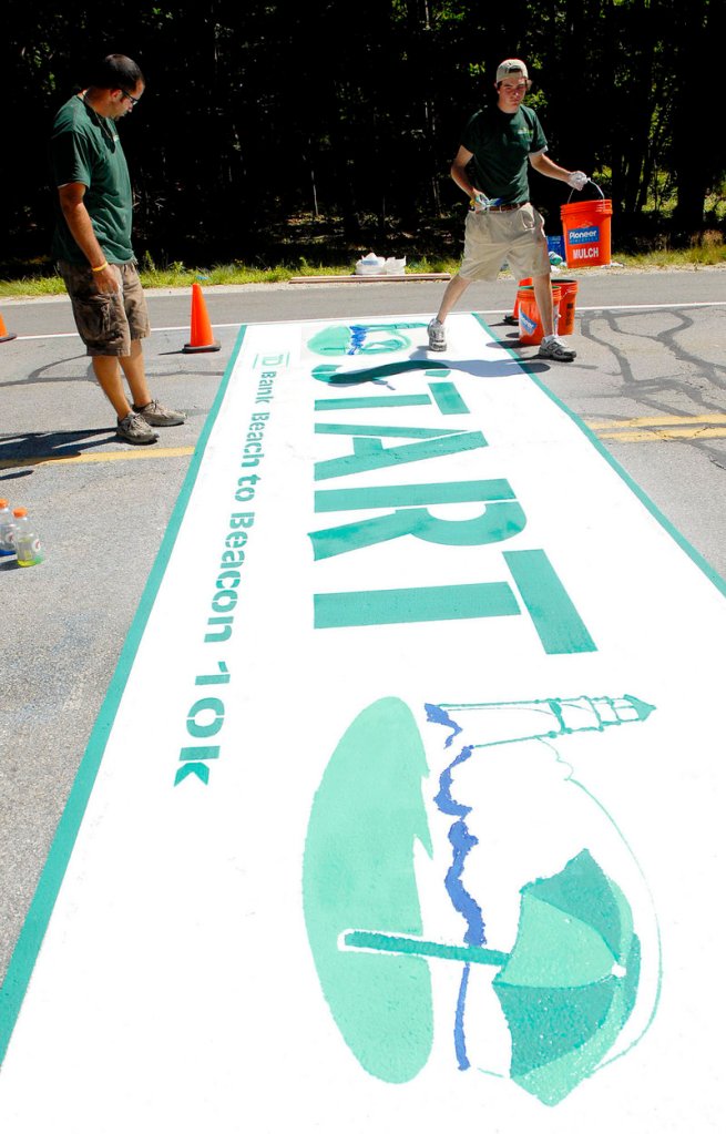 Volunteers Mike DiDonato, left, and Ryan McGillivray put the finishing touches on the Beach to Beacon starting line Saturday.