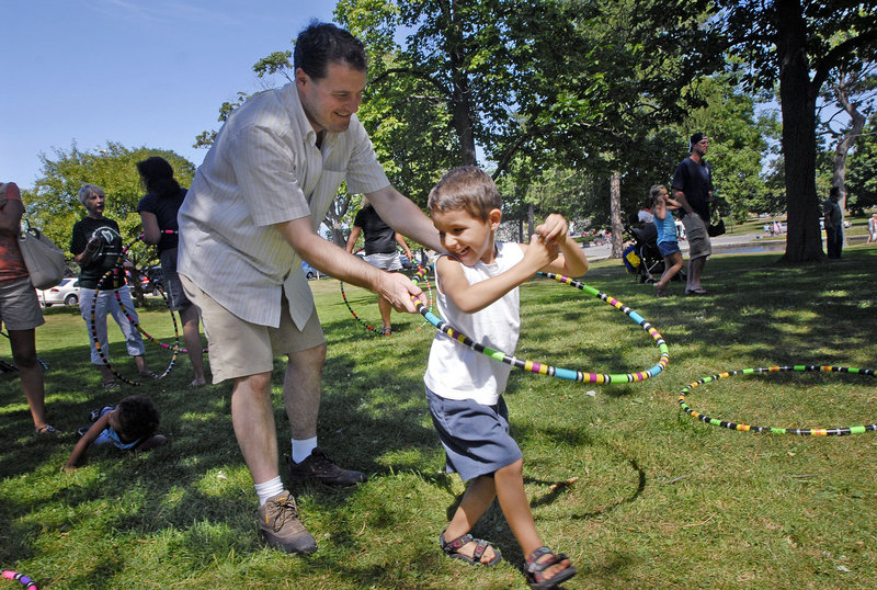 Benicio Collings, 4, of Portland gets some help with a hula hoop from his father, Ben Collings, during the Festival of Nations in Deering Oaks in Portland on Saturday. Tracy Tingley of Hardcore Hoops in Portland provided the hoops for the event.