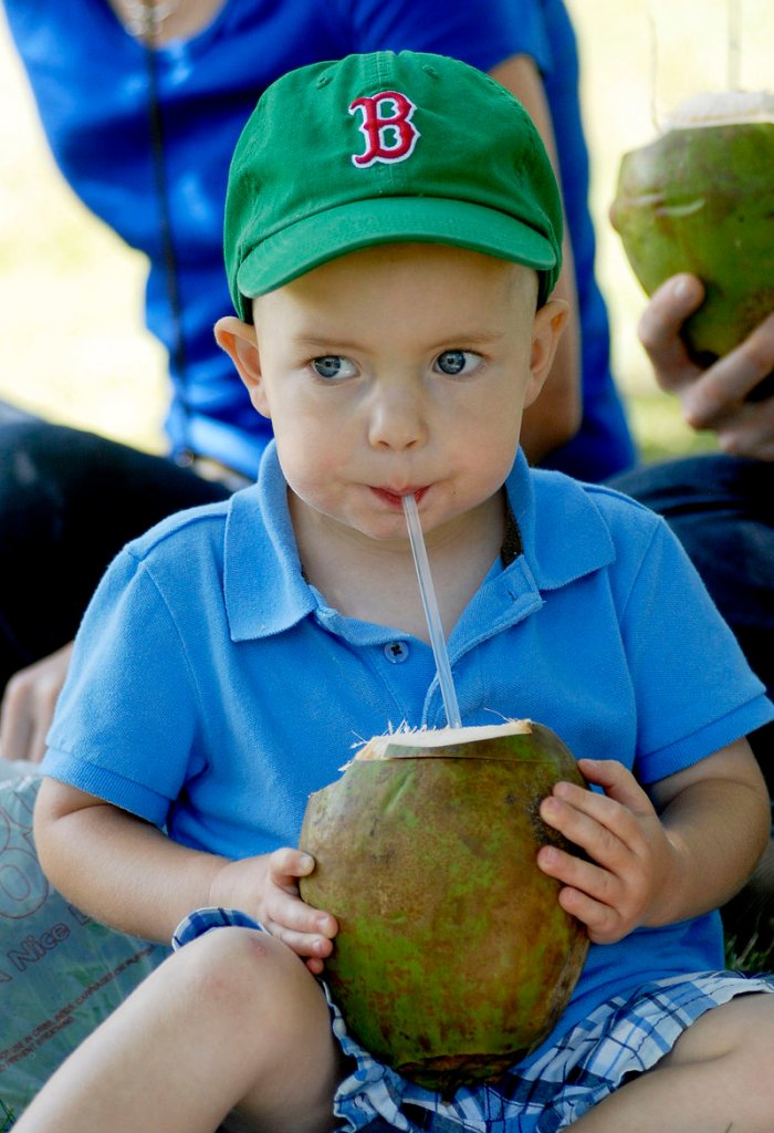 Noah Timmins, 2, of Portland enjoys coconut juice fresh from the fruit at the Festival of Nations. Saturday’s event included vendors of ethnic food and crafts as well as dance and music performances.