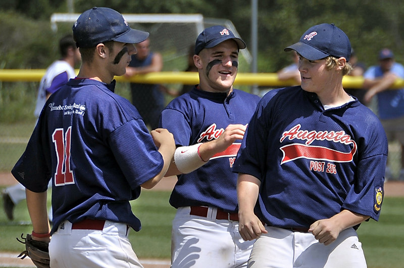 Jake Beland of Augusta, right, is congratulated by Nick Lucas, left, and Corey Lapierre after pitching the first complete game of the American Legion state tournament.