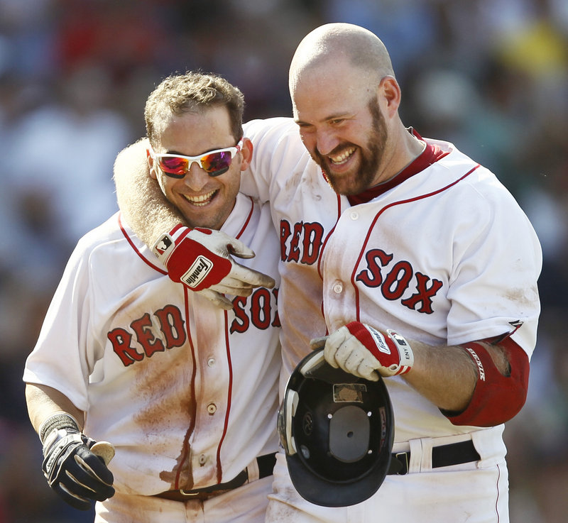 Marco Scutaro, left, gets a hug from Kevin Youkilis after Scutaro’s bunt single in the bottom of the ninth scored Darnell McDonald and sent the Red Sox past the Tigers, 4-3.