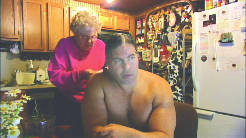 Stan Pleskun's mother braids his hair in "Strongman." The movie follows Pleskun's efforts to make a reputation with his physical gifts.
