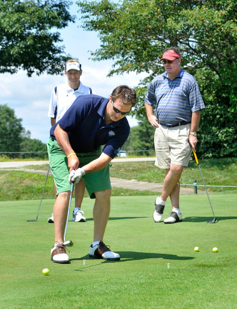 Peter Metcalf, the last Maine hockey captain under Shawn Walsh, participates in a putting contest.
