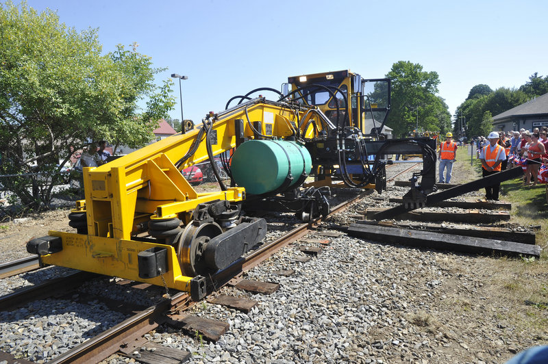 Railroad construction crews demonstrate how old rail ties are removed and replaced with new ones Monday, when work began on tracks to extend the Downeaster train service from Portland to Brunswick. The expanded service is scheduled to begin in the fall of 2012.