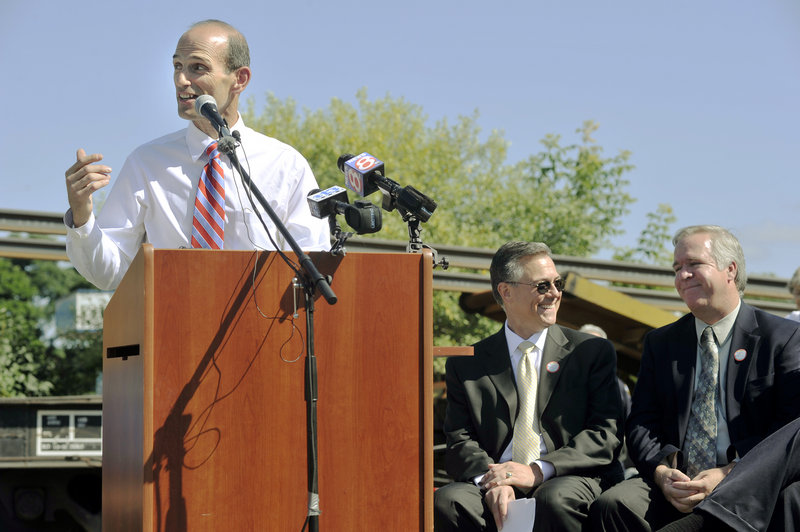 Gov. John Baldacci addresses several hundred people on hand to mark the beginning of the expansion of the Downeaster train service. Seated, from left, are Joseph Szabo, head of the Federal Railroad Administration, and state Transportation Commissioner David Cole.