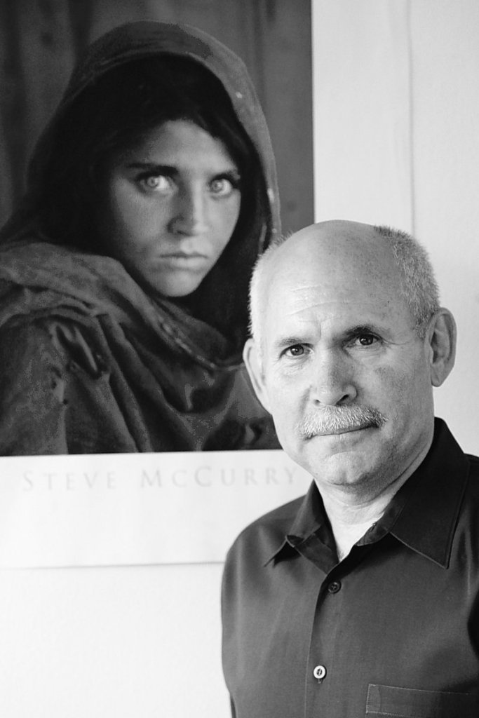 Steve McCurry poses for a portrait in New York with a poster of his iconic photograph of an Afghan refugee girl. McCurry used the last roll of Kodachrome produced to photograph the Brooklyn Bridge, Grand Central Terminal and human icons including Robert De Niro. Kodak discontinued the film last August.
