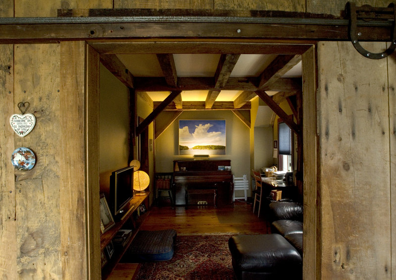 An old barn door rolls open to reveal a home office.