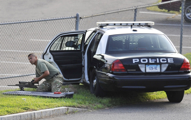 A police officer sets up his weapon outside Hartford Distributors. Gunman Omar Thornton was alive when police arrived at the scene but killed himself before officers got to him.