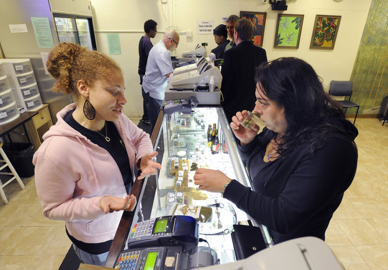 Grey, a clerk who asked that her last name not be used, helps patient Sara Romano select some marijuana at the Berkeley Patients Group clinic in Berkeley, Calif.