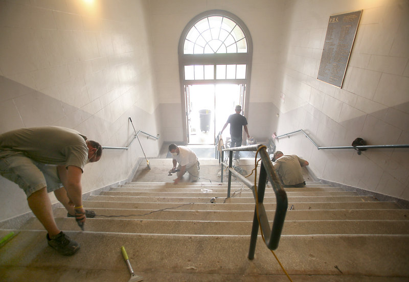 Workers restore the terrazzo tile stairs last week in the foyer of Portland High School. "This is a work of art," said Tony Celeste, the contractor who is restoring the finish after removing cement, rusted steel and rubber tread that had covered the stairway for more than two decades.