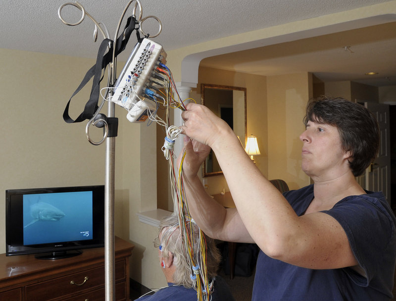 Medical Technician Tammie Radke prepares Bob Abbott for a sleep study Thursday evening, attaching about 32 monitoring devices to him in a Southern Maine Medical Center sleep lab at the Comfort Inn in Biddeford. The electrodes monitor breathing, heart rate and brain activity.