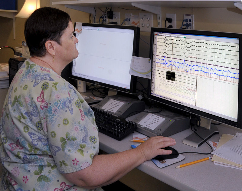 Medical Technician Betsy Eide sets up a computer monitoring program Thursday for one of two patients she will observe overnight for a sleep study at the Comfort Inn.