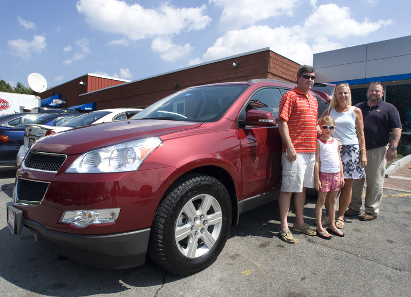 Todd and Dawn Flaherty and their daughter, Brooke, stand in front of their newly purchased 2010 Traverse crossover SUV with sales manager Russ Rogers at Pape Chevrolet in South Portland.