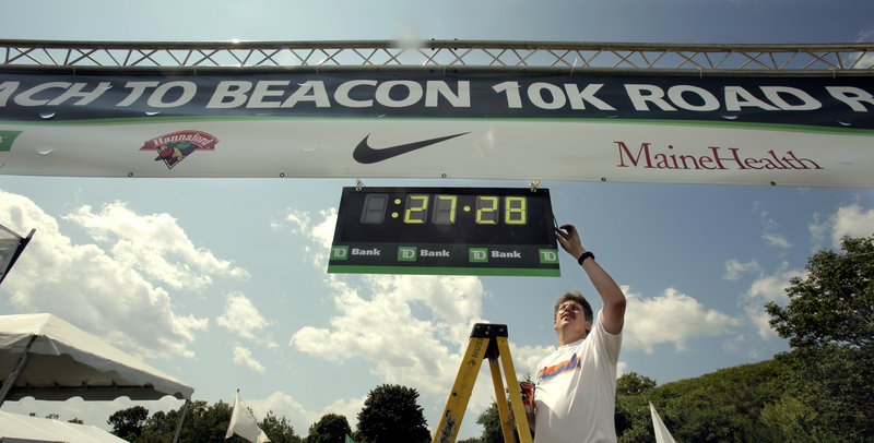 Steve Bedsole turns off power to a race clock at the finish line of the TD Bank Beach to Beacon 10K. The time of 27 minutes, 28 seconds is the course record.