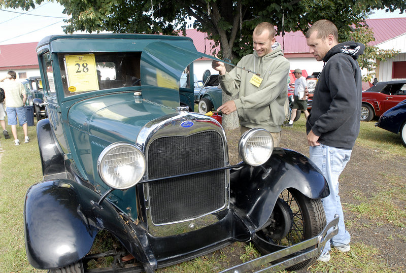 Tim Hayes, left, and Andrew Hayes, both of Gray, look over a 1921 Ford Model T prior to the auction Saturday. The car was one of more than 100 in Phil Hall’s collection that went on the auction block, taking in a total of more than $1.3 million.