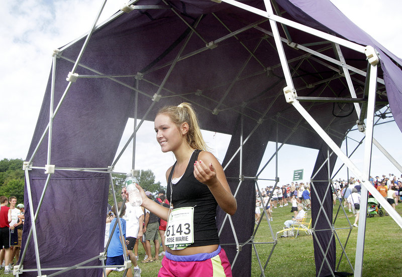 Rose Marie Parry of Ponte Vedra Beach, Fla., cools off in the mist tent after finishing the race. Parry, 16, had an official time of 56 minutes, 7 seconds.