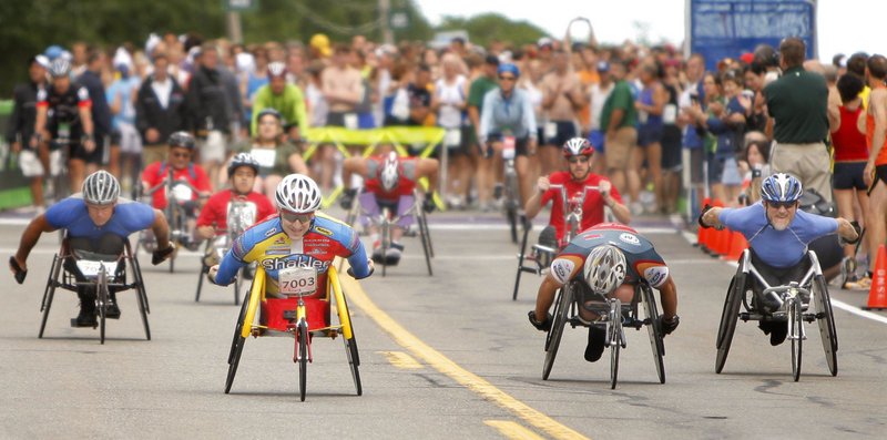 Wheelchair competitors burst from the starting line while the pack of runners waits for the chance to begin the 10-kilometer trek to Fort Williams Park.