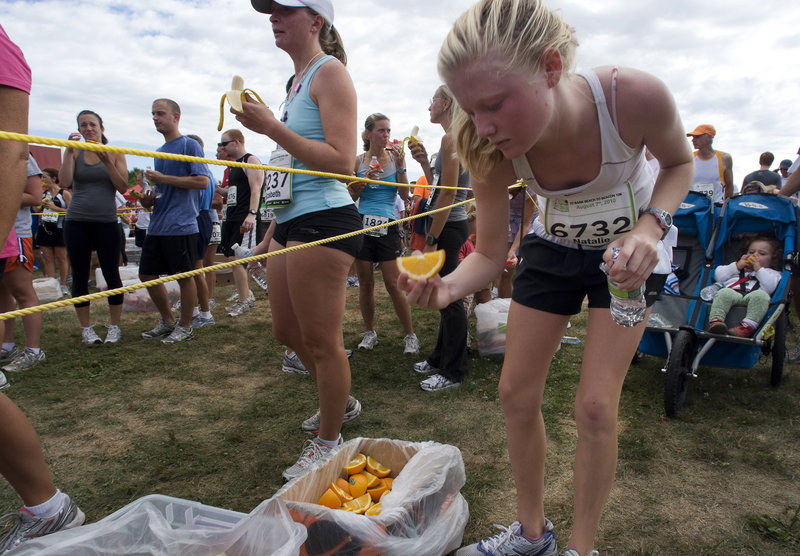 Natalie Rand, 14, of Cape Elizabeth grabs some refreshments after finishing the race. Rand completed the course in 52 minutes, 46 seconds.