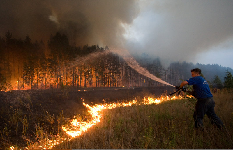A firefighter battles a wildfire last week near the village of Dolginino, Russia. Climate scientists want better computer modeling to predict weather havoc like this summer’s heat wave in Russia and floods in Pakistan. They will discuss such tools in meetings this month and next in Europe and the United States.