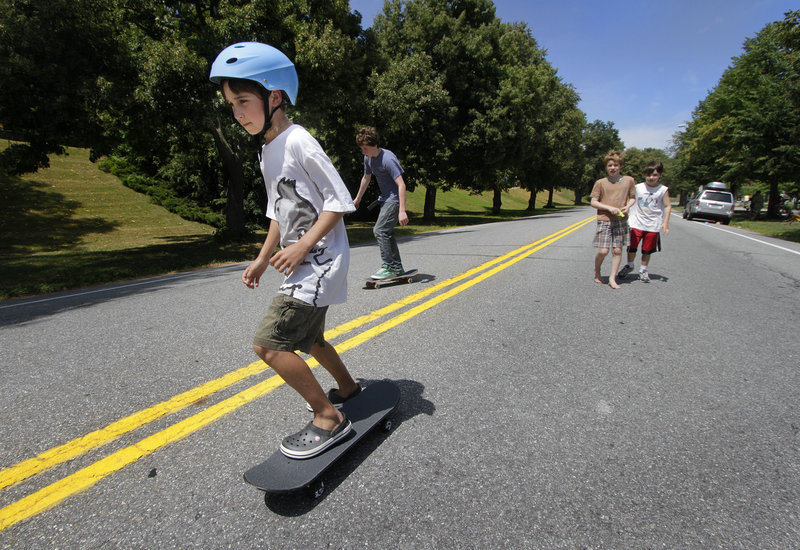 Nine-year-old Henry Spritz skateboards with friends on a section of Baxter Boulevard that was closed down Sunday for the Back Cove Neighborhood Association block party.