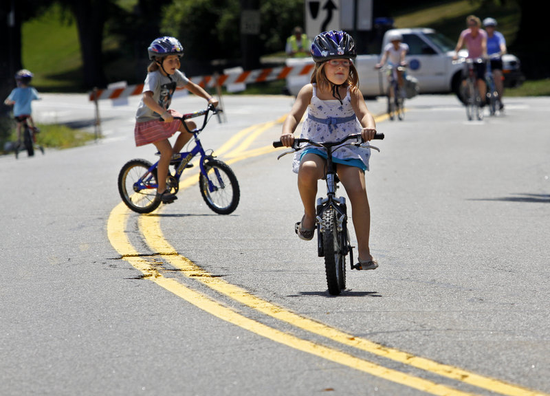 Anya Criden-Clark and her sister Eva, both 7, ride on Baxter Boulevard during Sunday’s Back Cove Block Party. The third annual event drew families eager to sample free refreshments, try out hula hoops and use skateboards and inline skates as well as going biking.