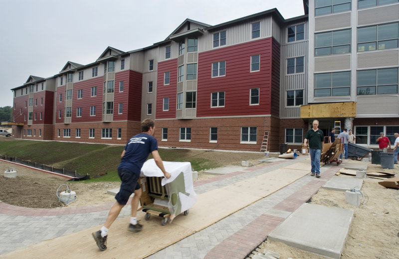 A mover pushes a chair into a new dorm – a 300-bed suite-style residence hall – at the University of New England campus in Biddeford last week.
