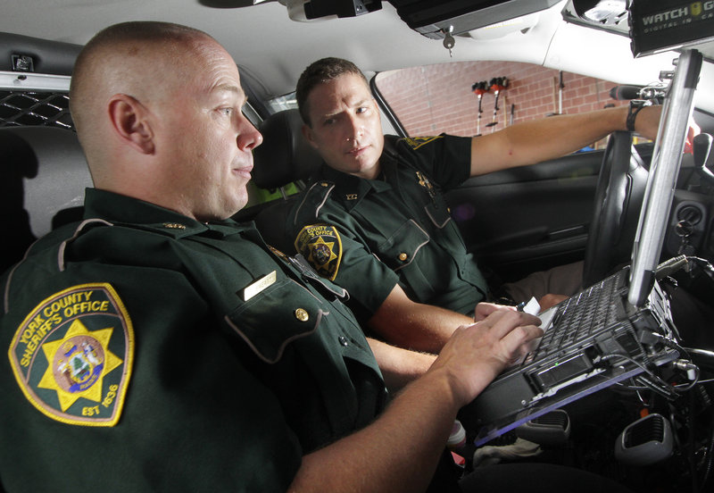 Deputy Corey Sweatt, left, trains Thomas Searway, one of four new York County Sheriff’s Office deputies, to use the vehicle computer on Monday. The department is now screening applicants for the last vacant deputy position, which will bring the department up to its full strength of 24.