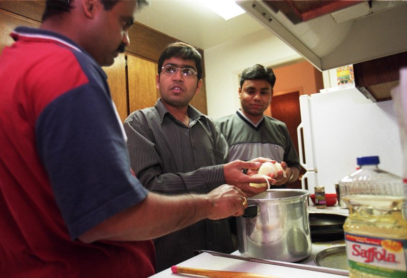 Pratap Yeware, left, Deepak Jaware, center, and Sudhir Wath share an apartment with two other men from India working in the U.S. on H1B visa status. A bill in Congress would raise visa fees for foreign workers.