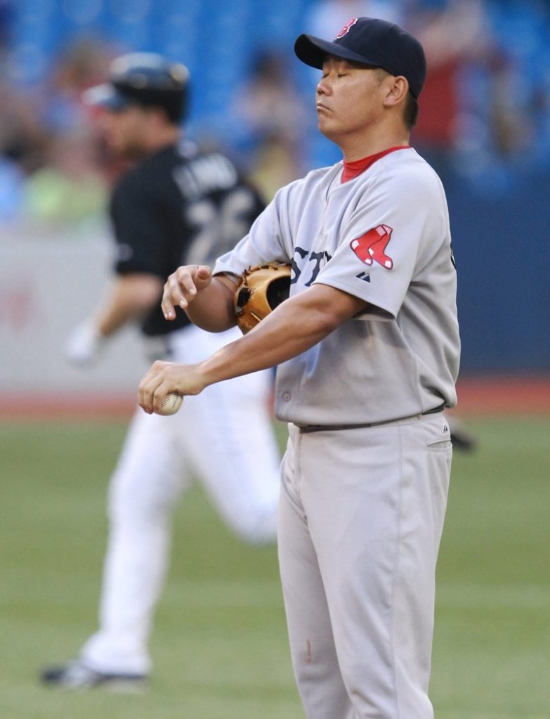 Daisuke Matsuzaka stands on the mound as the Blue Jays’ Adam Lind rounds the bases following a solo home run in the second inning Tuesday night in Toronto.