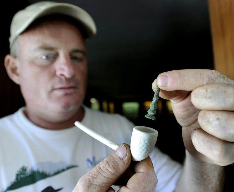 Tom Desjardins, a historian with the Maine Bureau of Public Lands, holds a brass tamper, used to tamp tobacco into a pipe in the late 1600s, that was found during excavations at the historic site this week.