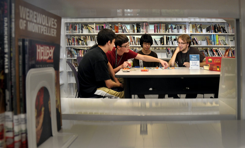The Portland Public Library’s teen librarian, Justin Hoenke, right, joins a group playing a board game called Settlers of Catan. The other players, from left, are Jake Tommer, 14, Kiril Sussky, 14, and Josh Tommer, 16.