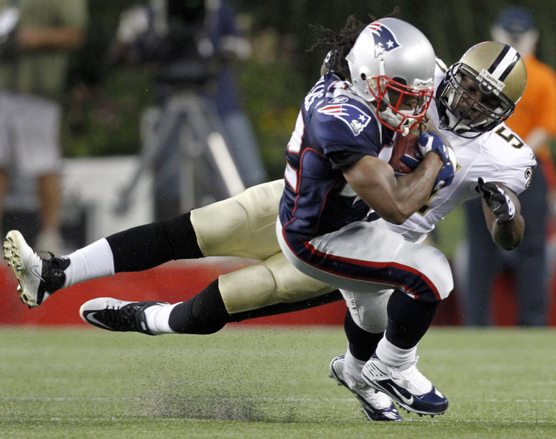 Patriots running back BenJarvus Green-Ellis protects the ball as he’s brought down by Saints linebacker Jonathan Vilma. Green-Ellis had a touchdown run in New England’s 27-24 exhibition win Thursday night.