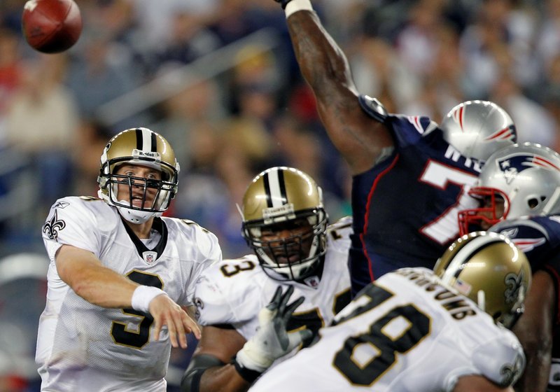 Saints quarterback Drew Brees, left, lets a pass fly as New England nose tackle Vince Wilfork fights off blockers and tries to deflect the ball. Brees was 9 for 13 for 55 yards in limited action in the exhibition opener at Foxborough, Mass.