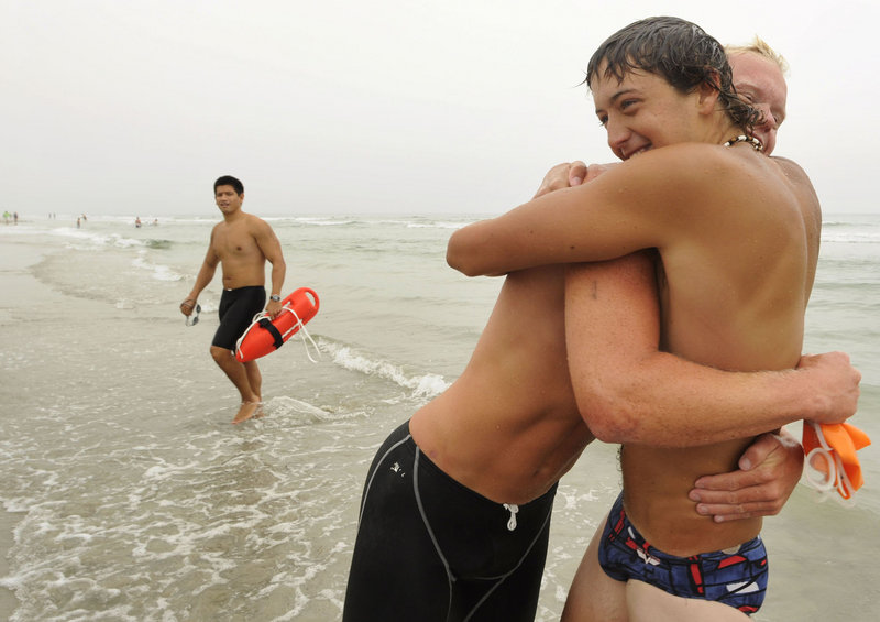 Adam Eramo, right, hugs one of his teammates from Salisbury Beach, Mass., the overall winners.