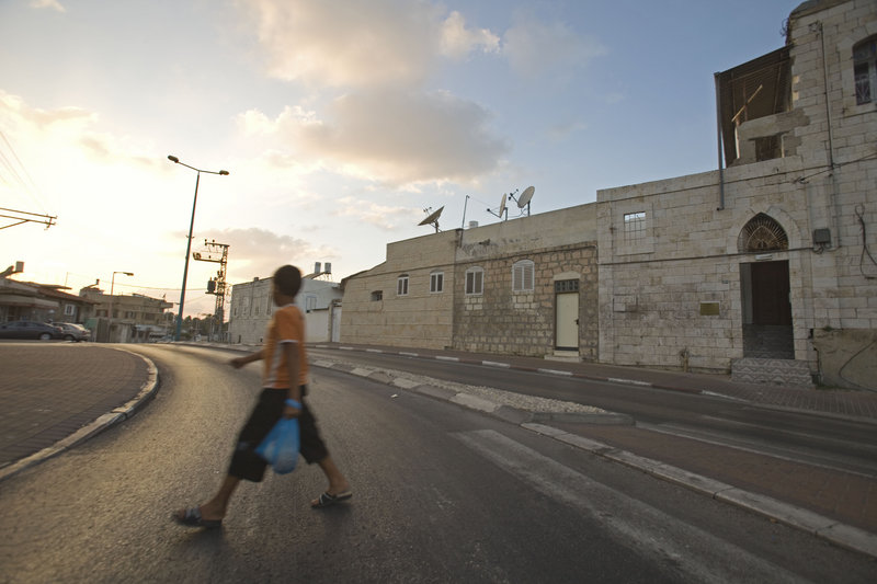 A youth walks by the home of Elias Abuelazam’s family in Ramle, Israel. Israeli police said Friday that Abuelazam, a suspect in a string of stabbings in the United States, also was a suspect in a separate stabbing attack in Israel earlier this year, although charges were never pressed.