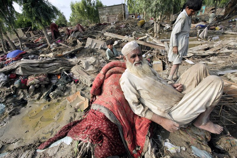 Villagers left homeless by recent floods sit in the rubble of their houses in Aza Khei, Pakistan, on Friday. In terms of the number of people affected, the disaster is worse than the 2004 Indian Ocean tsunami, the 2005 Kashmir earthquake and January’s Haiti earthquake combined, the U.N. says.