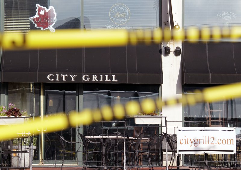 Crime scene tape is stretched across windows that were broken in a train terminal across the street from the City Grill in Buffalo, N.Y., during Saturday’s fatal shootings.