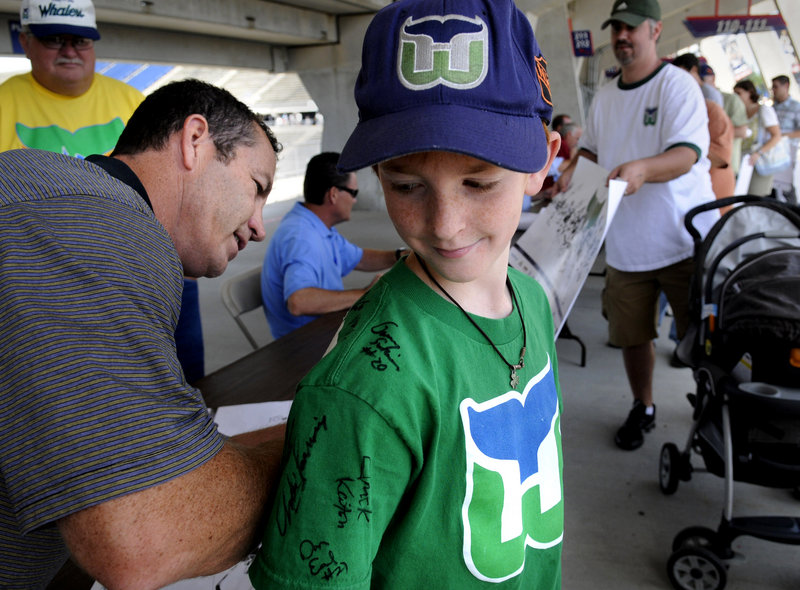 Portland Pirates Coach and longtime Hartford Whalers fan favorite Kevin Dineen, left, signs the jersey of Conor Quinn, 12, of North Haven, Conn., on Sunday in East Hartford, Conn. About two dozen former players and 5,000 fans attended the Whaler Fan Fest, one of several events planned by former Whalers owner Howard Baldwin in an effort to show the NHL that there is enough support to bring the league back to city. The Whalers left Hartford and became the Carolina Hurricanes in 1997.