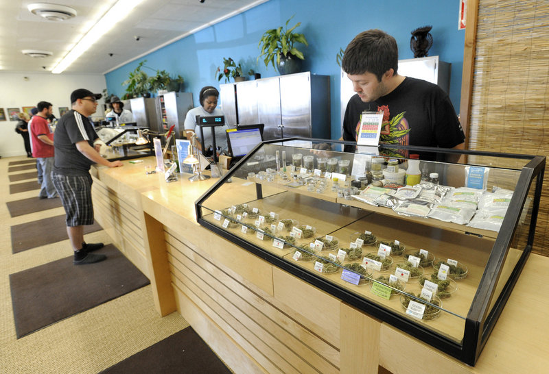 Employee Derek Flores, right, waits for a patient at a display case at the Harborside Health Center in Oakland, Calif. The center will be one of the models for Maine's first medical marijuana dispensaries.