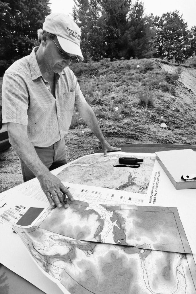 Geologist John Brooks checks on maps in New Hampton, N.H.