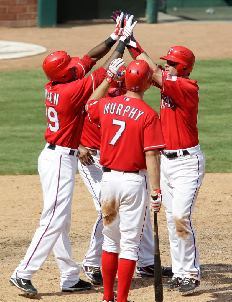 Texas’ Julio Borbon, left, David Murphy and Elvis Andrus, rear, congratulate Michael Young, right, after Young’s three-run homer in the seventh inning.