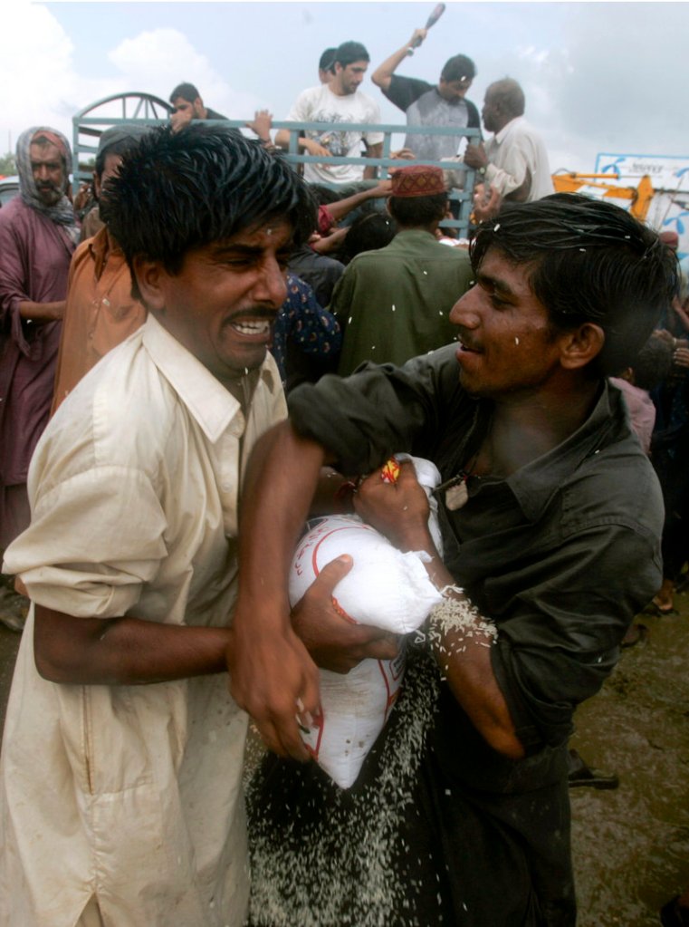 Flood victims grapple for food Monday in Shekarpur, Pakistan. About 20 million people have been affected by the nation’s worst disaster.