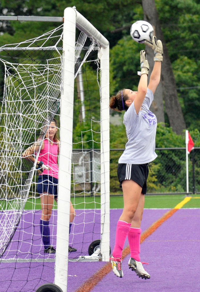 Moira Trynor, a senior goalkeeper, deflects a shot over the crossbar during the Deering girls' soccer team's first practice of the season.
