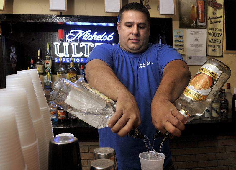 Chris Steele, co-owner and bartender at the Oasis, mixes up the house special, the Oasis Punch.