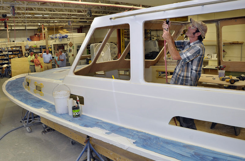 A tour group gets a close-up view of the boat-building process during an open house Tuesday at Sabre Yachts in Raymond.