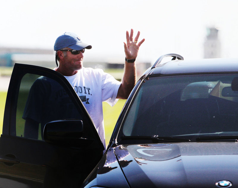 Brett Favre waves to the media and fans Tuesday after arriving by a private jet at Flying Cloud Airport in Eden Prairie, Minn., to rejoin the Vikings in training camp.