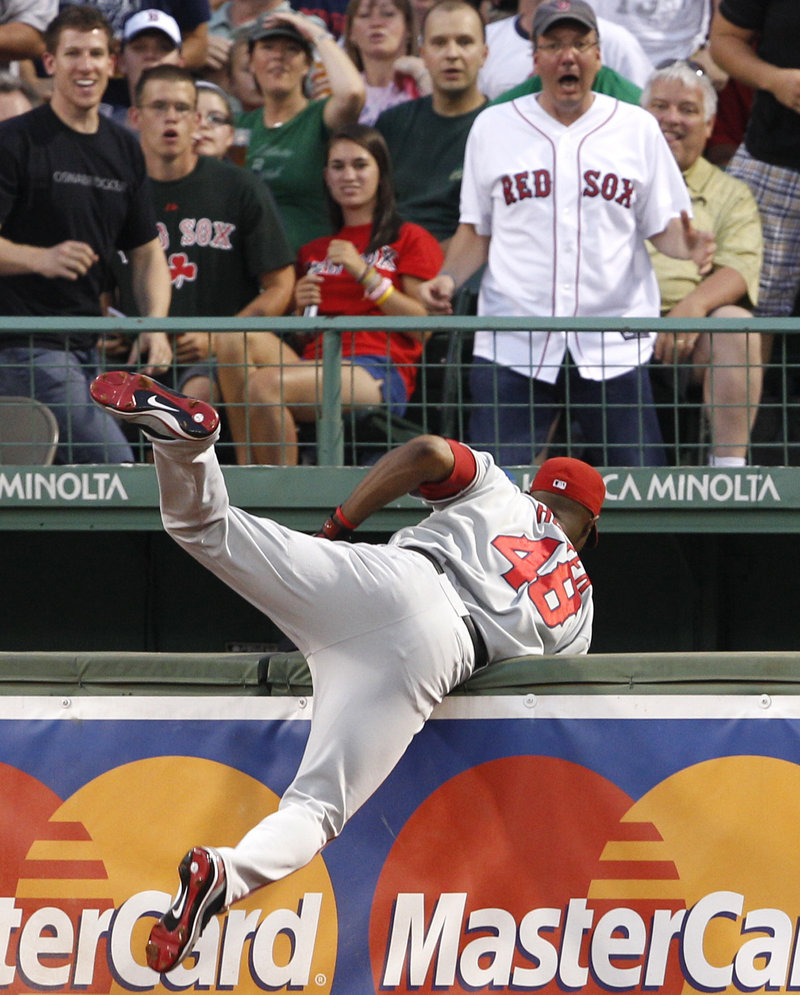 Angels right fielder Torii Hunter almost falls into the bullpen after catching a drive by Boston’s Adrian Beltre on Tuesday night at Fenway Park.