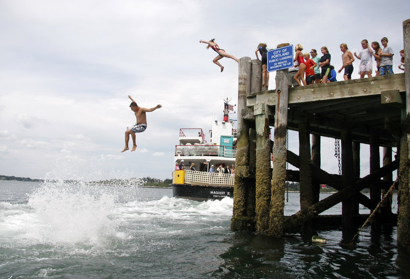 Participants take the “Big Jump” off the dock on Cliff Island into the wake of a Casco Bay Ferry vessel as it departs just after noon Wednesday. The total number of jumpers fell far short of the record for the annual summer tradition.